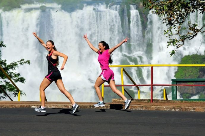 Duas mulheres correm com o visual da Maratona das Cataratas que acontece em maio