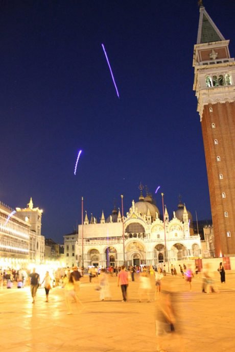 Pequenos brinquedos luminosos recebem os viajantes no céu da Praça São Marco