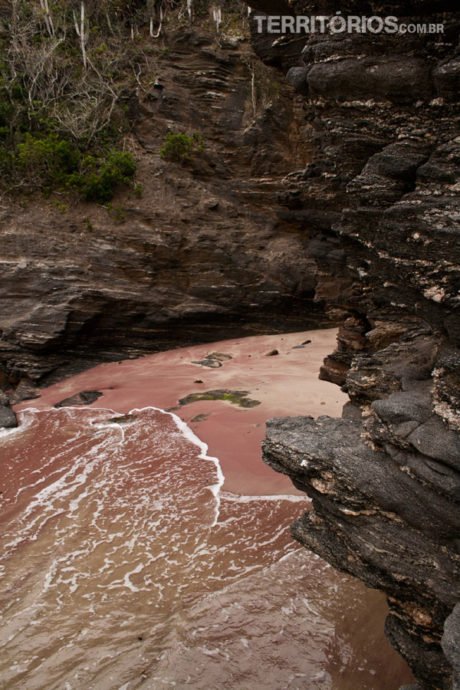 Areia vermelha no canto escondido da Praia do Forno