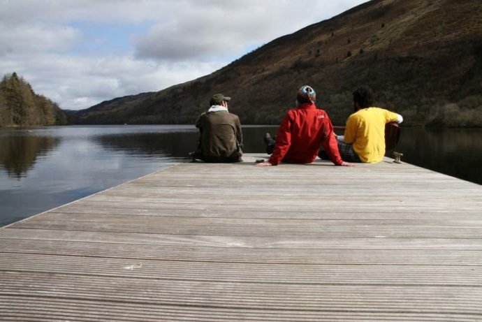 Sentados no píer do lago na Escócia