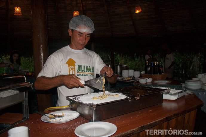 Cozinheiro pergunta qual o recheio enquanto prepara a tapioca