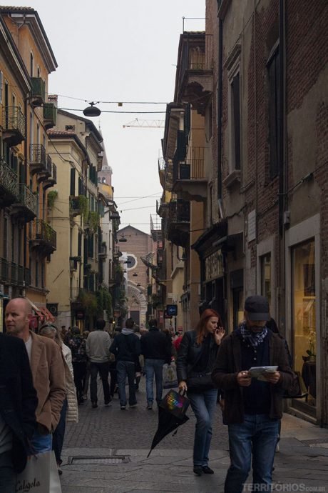 Rua estreita e com comércio em Verona