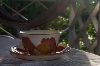 Xícara de café florida servida em mesa na varanda