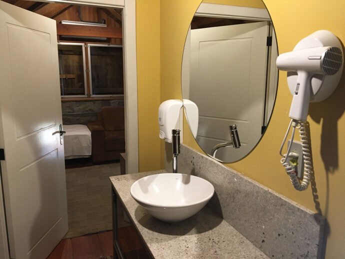 No corredor da suíte, pia e secador de cabelo para o hóspede