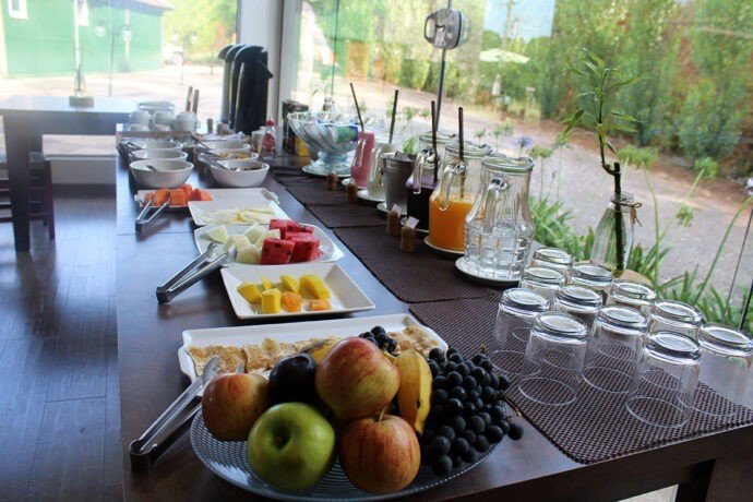 Uma das mesas do salão é composta com frutas, sucos, cereais e café com leite