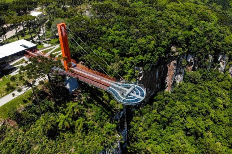 Estrutura de vidro e aço avança 35 metros sobre o Rio Caí a 360 metros de altura. Foto aérea da plataforma em meio a natureza exuberante