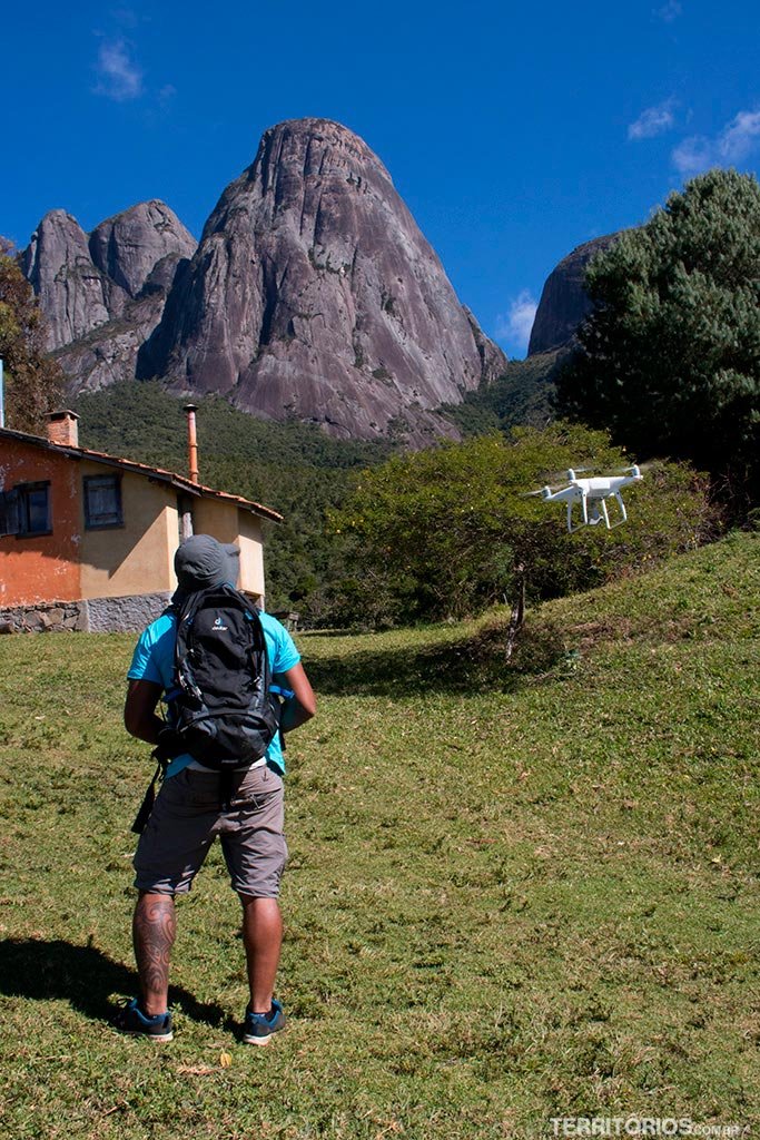 Homem pilota drone em frente a montanha - Drone da Montanha