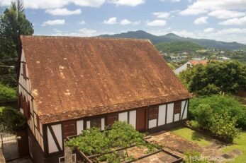 Caixa enxaimel com jardim, céu com nuvens e vista para as montanhas de Novo Hamburgo