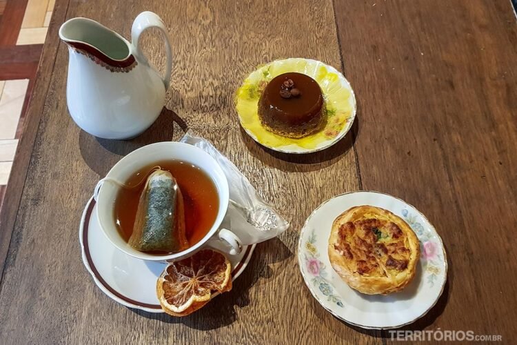 Chá, bule e dois pratos com doces