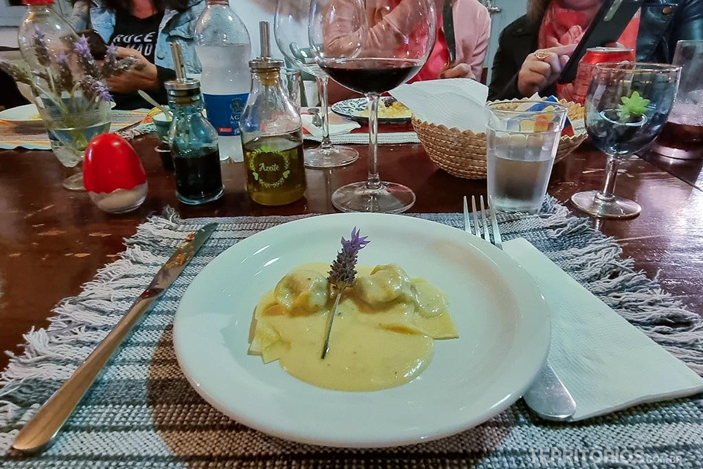 Prato servido com massa, queijo e flor de lavanda em uma mesa de madeira na Casa Olga, em Monte Belo do Sul