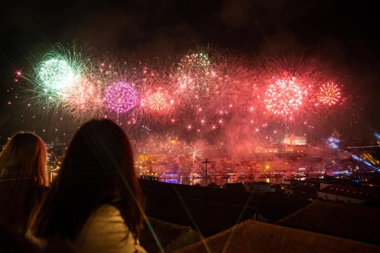 Fogos de artifício coloridos no céu de junho, pessoas assistem