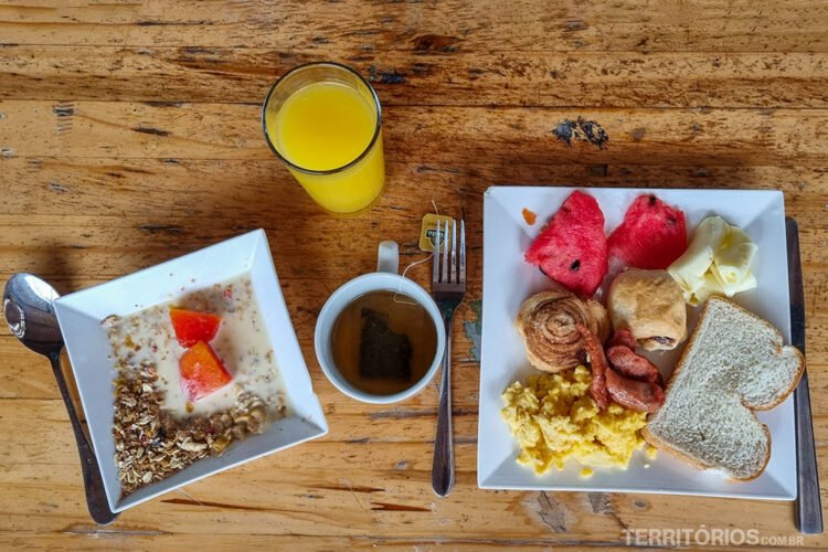 Mesa de madeira com pratos servidos para o café da manhã