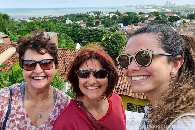 Três mulheres fazem pose com vista para Recife