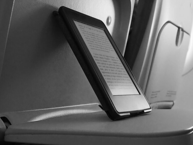 Tablet apoiado em mesa no assento do avião. Boa compra na Amazon Prime Day.