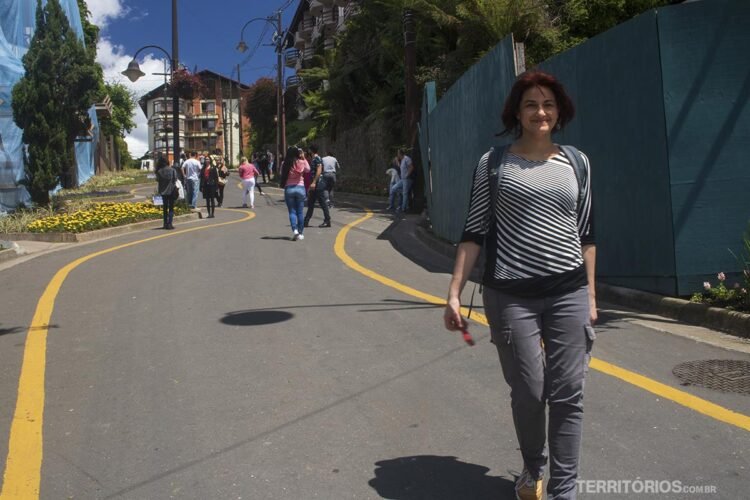 Mulher caminha na Rua Torta entre as atrações em Gramado