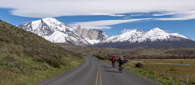 Ciclistas em estrada asfaltada rumo ao Parque Nacional Torres del Paine