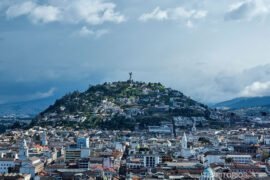 Próxima viagem: Equador Indice Equador, centro de Quito com colina no meio. Céu azul com nuvens.