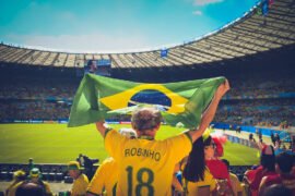 Futebol e Brasil: Uma História de Amor Torcedor de futebol e Brasil segura a bandeira em estádio de futebol.