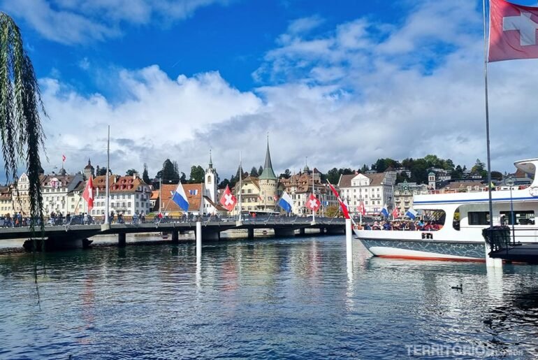 Céu com nuvens, casas na margem do lago Lucerna com barco
