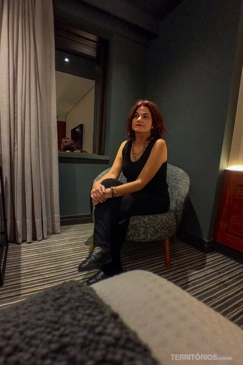 Mulher sentada em suíte do Hotel Laghetto Stilo São Paulo