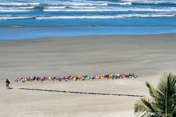 Vendedor ambulante com seus balões coloridos caminha na areia da praia da Riviera de São Lourenço