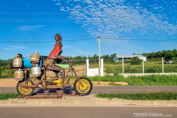 Escultura em ferro de homem em moto carregada de botijões fica na entrada de Melo