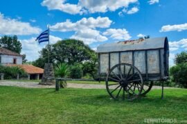 Clima no Uruguai e eventos da primavera Carroça antiga no gramado verde ao lado da bandeira em clima no Uruguai