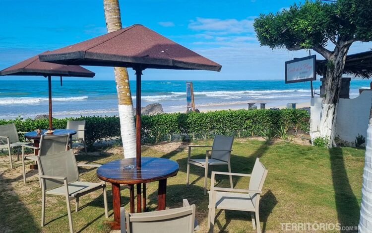 Jardim com mesa, cadeira e sombrero em frente a praia da ilha Isabela