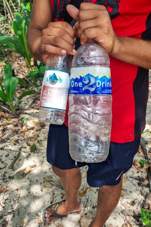 Homem de blusa vermelha e bermuda azul garrafas de plástico com rótulo de outros países