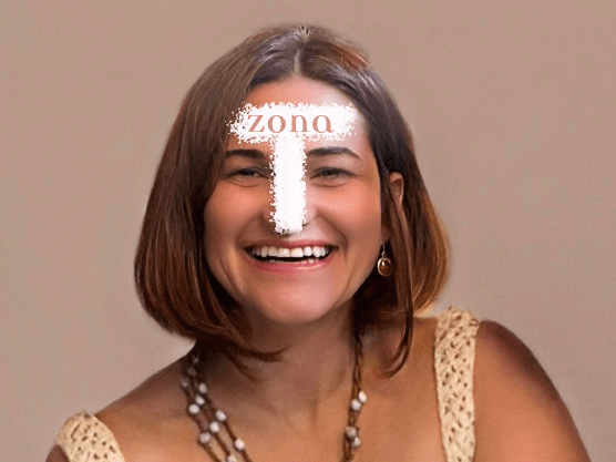 Rosto de mulher morena de cabelos pelo queixo sorri. Desenho de letra T branca escrito zona marca a Zona T do rosto.