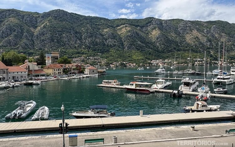 Marina de Kotor com muitos barcos, montanhas e céu azul