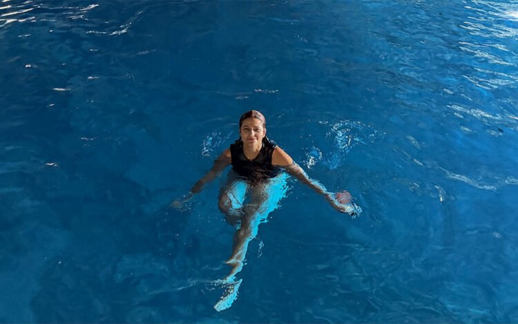 Mulher morena de maio preto em azul azul na caverna da Baía de Kotor 