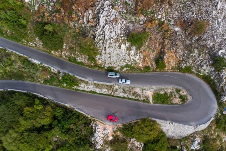 Estrada em gancho com mirante e três carros